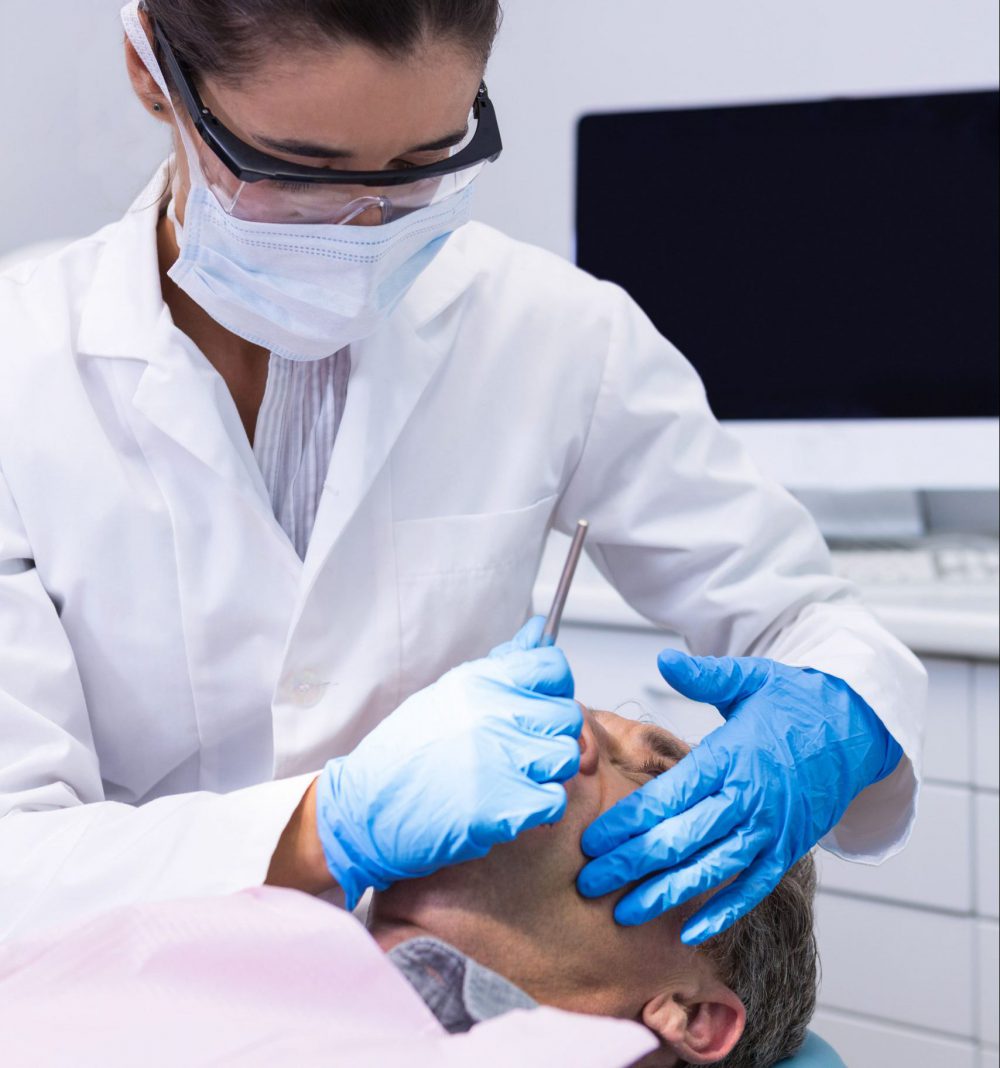 man-receiving-dental-treatment-by-dentist-43X9REJ